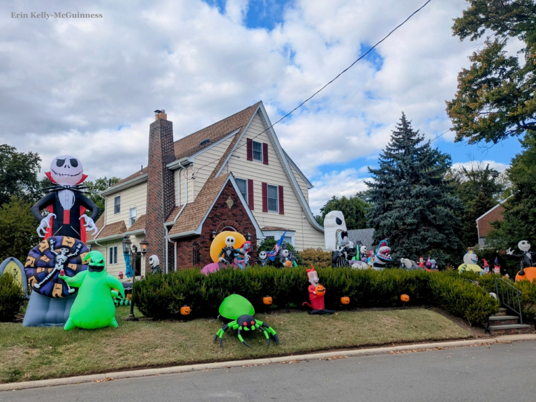 Rahway home featuring full front-yard haunted house decorations with skeletons, cobwebs, and eerie lighting.