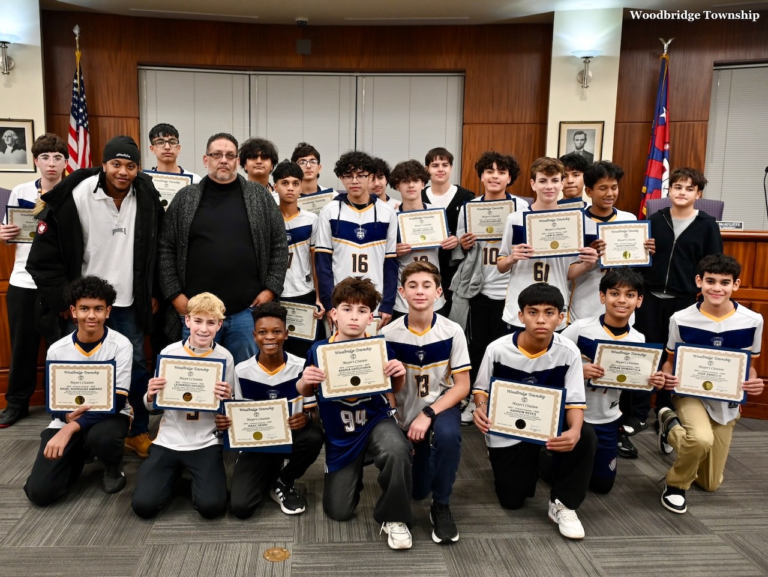 The Colonia Cosmos boys soccer team poses with certificates inside Woodbridge Town Hall during a council ceremony recognizing their championship season.