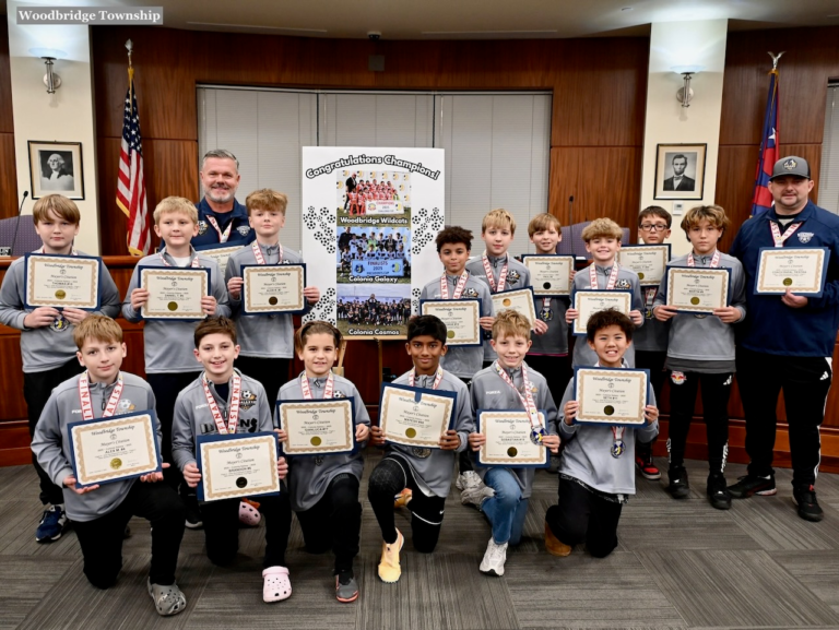 Members of the Colonia Galaxy boys soccer team hold certificates as they pose with their coaches at Woodbridge Town Hall after being honored for their Presidents Cup title.