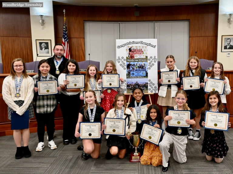 The Woodbridge Wildcats girls soccer team poses with medals and certificates at Woodbridge Town Hall after being recognized for winning the New Jersey Youth Soccer State Cup.