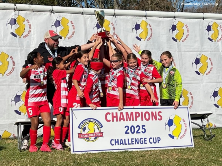 The Woodbridge Wildcats girls soccer team raises their trophy after winning the 2025 New Jersey Youth Soccer Challenge Cup.
