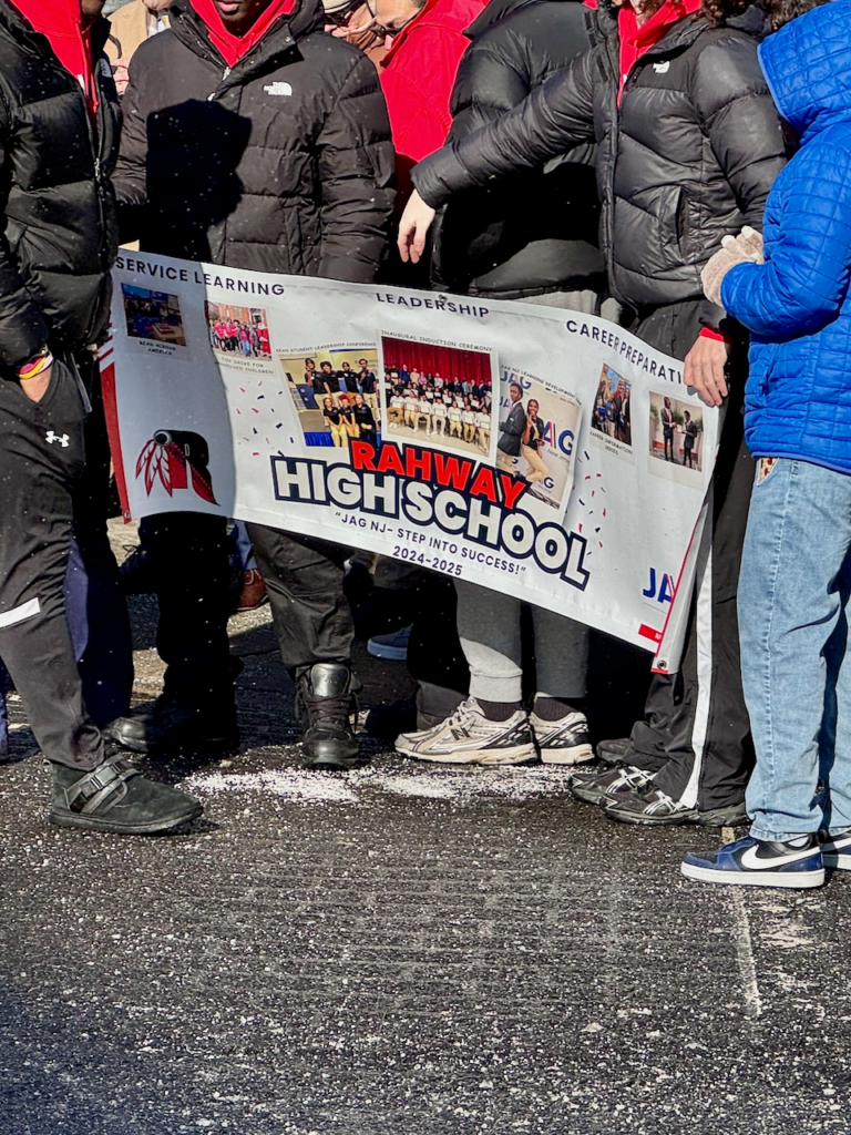 Students and participants hold a Rahway High School banner during the Martin Luther King Jr. Day march, highlighting youth involvement and service learning programs.